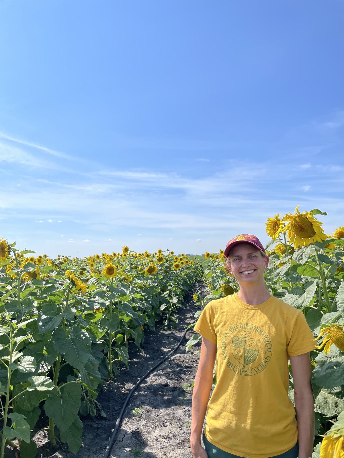Megan McCaghey standing by a sunflower field